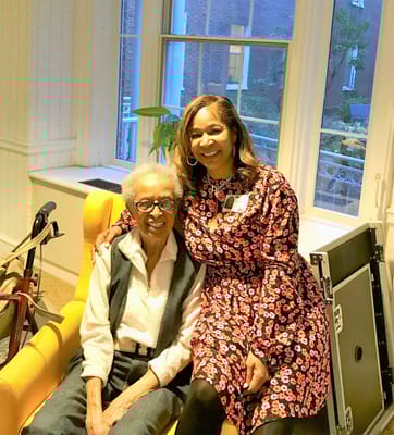 A staff member sitting with a resident in a common area