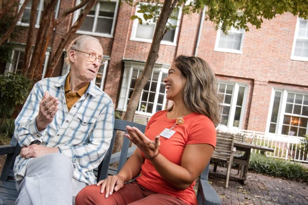 A resident and staff member chatting in the garden