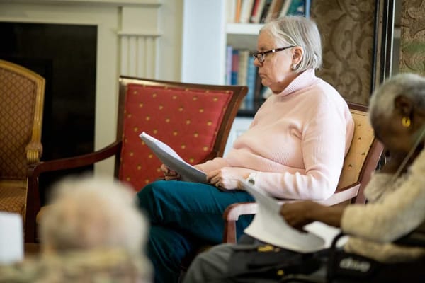 A resident quietly reading in a cozy lounge area