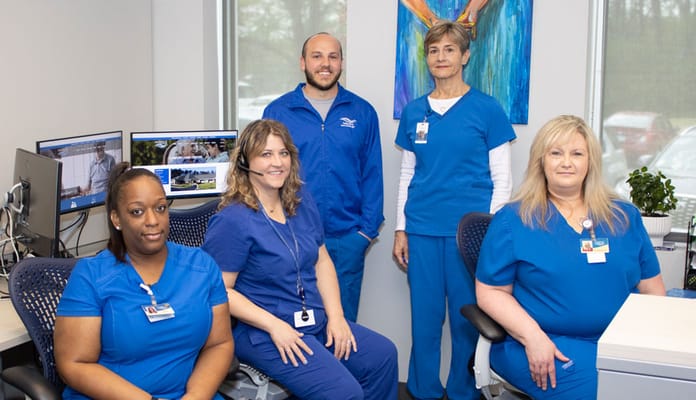 Staff members in blue uniforms at a desk