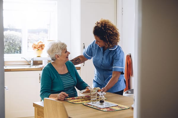 Staff assisting a resident in a kitchen setting