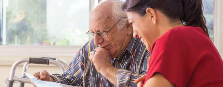 Senior resident and staff member engaging over documents