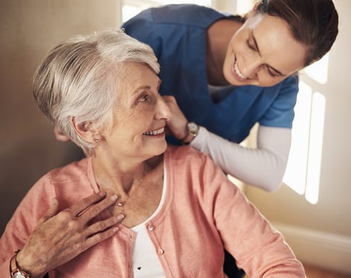 A caregiver smiling and interacting with a senior resident