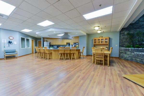 Common area with seating and kitchen in a senior living facility
