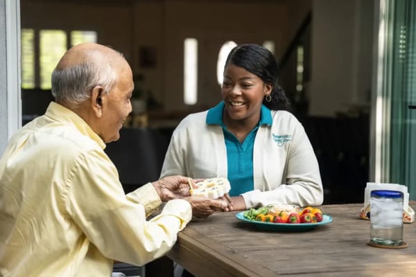 A caregiver interacting with a senior over a meal