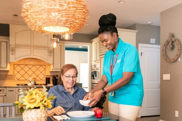 Staff member serving food to a resident in a dining area
