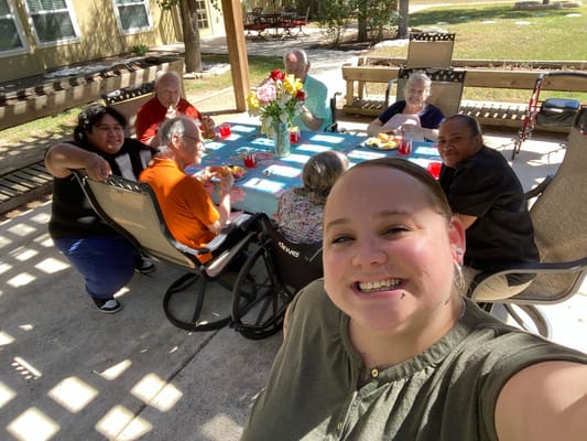 Residents and staff enjoying a meal outdoors