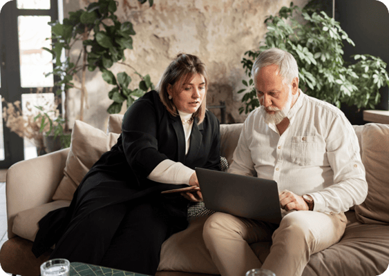 Staff assisting a resident with a laptop in a common area