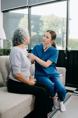 A caregiver checking a senior's heart rate in a cozy setting