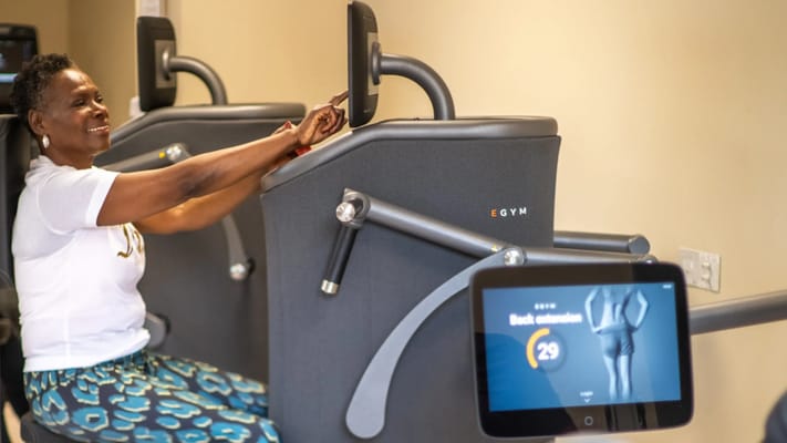 Resident using EGYM equipment in an interior fitness area