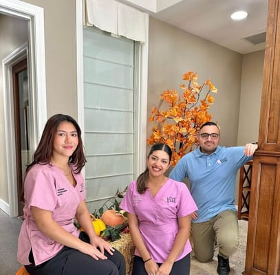 Staff members posing in a well-decorated common area