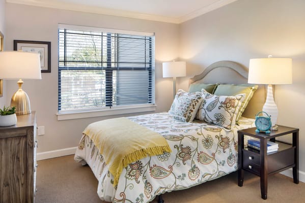 Cozy resident room with floral bedding and a window