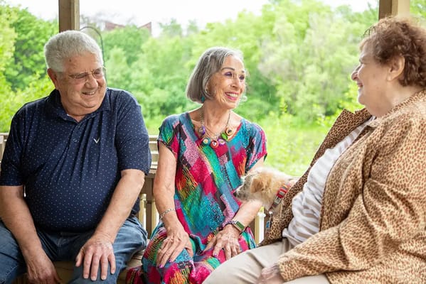 Three residents smiling together outdoors