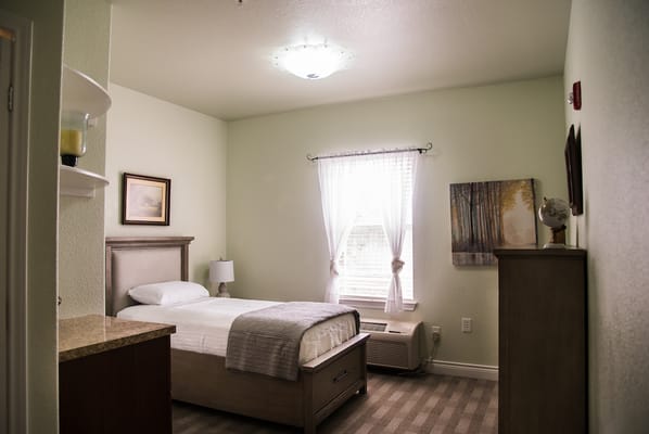 A cozy resident room with a single bed and natural light