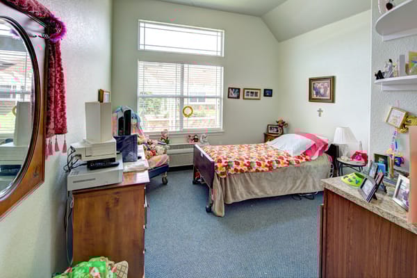 Bright private resident room with floral bedding