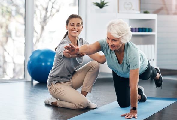 A staff member assisting a resident during a fitness session