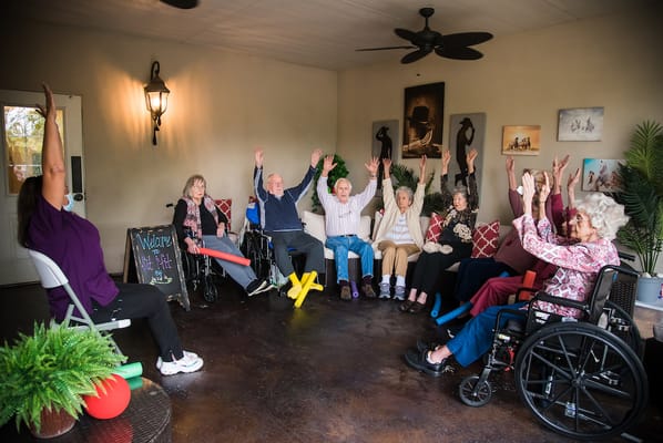 Residents engaging in a seated exercise class indoors