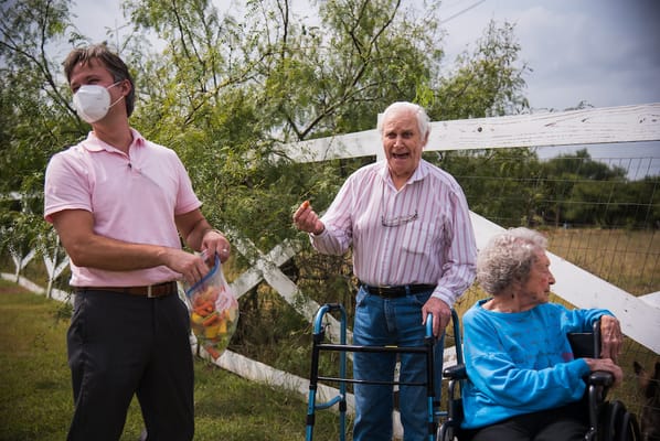 Residents enjoying snacks outdoors with staff
