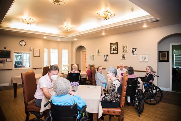 Residents engaging in conversation around dining tables