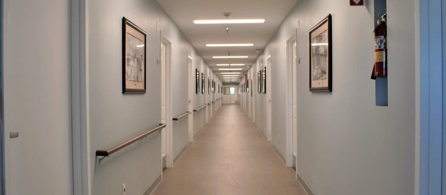 Well-lit corridor with framed artwork on the walls