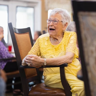 Smiling elderly woman in a bright social setting