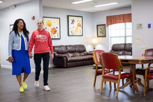 Two residents walking in a cozy common area