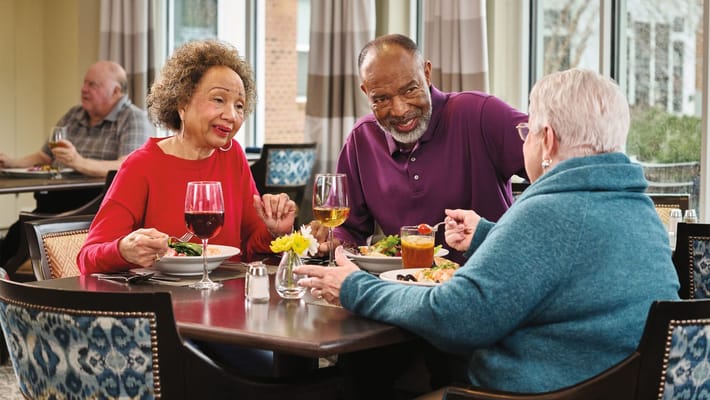 Residents enjoying a meal together in the dining room