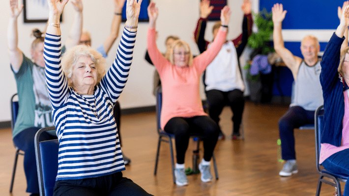 Residents participating in a seated exercise class