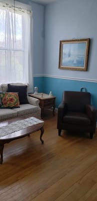 Cozy living room corner with blue walls and artwork