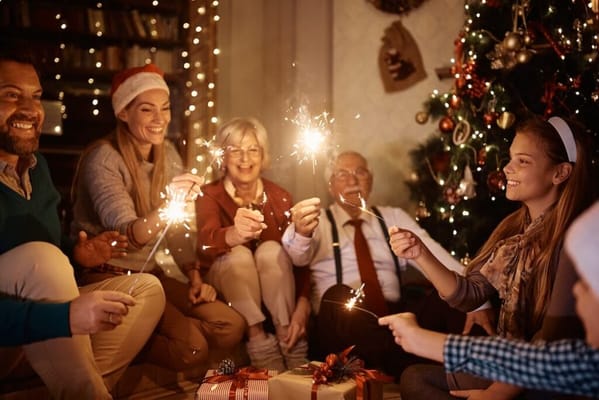 Residents and staff celebrating with sparklers during a holiday gathering