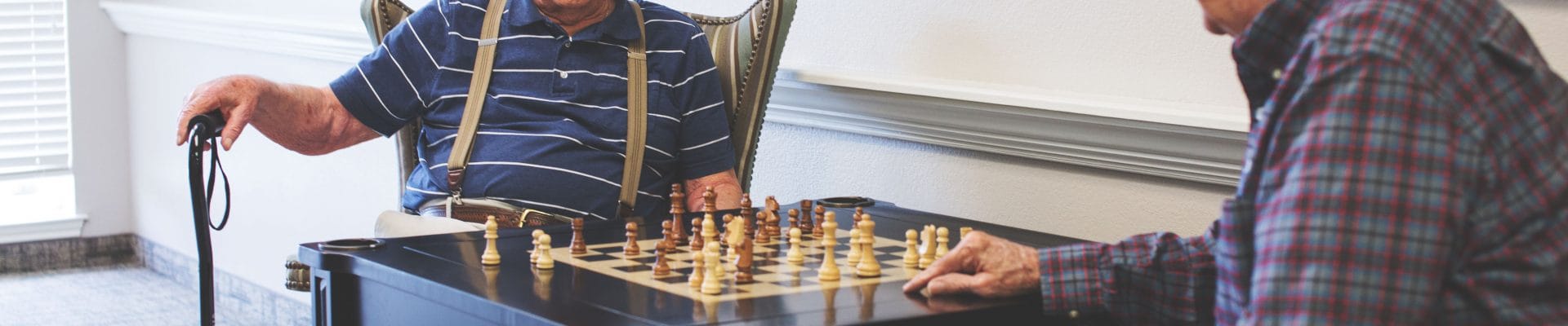 Two residents playing chess in a communal area