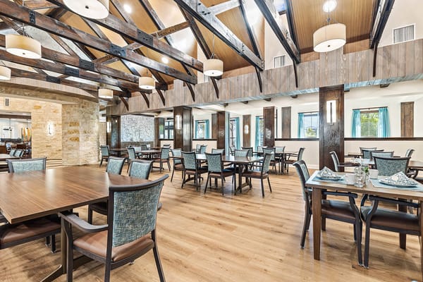 Dining room with wooden beams and tables set for meals
