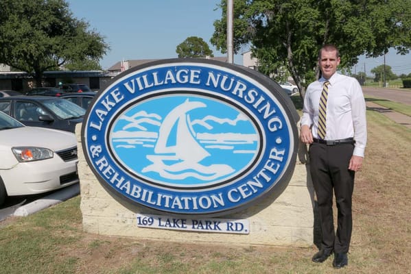 Facility signage with staff member in front