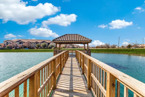 View of a wooden pier leading to a gazebo over water