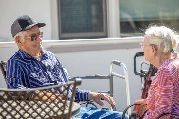 Residents chatting outdoors in bright sunlight