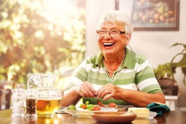 Smiling senior woman preparing food at a table