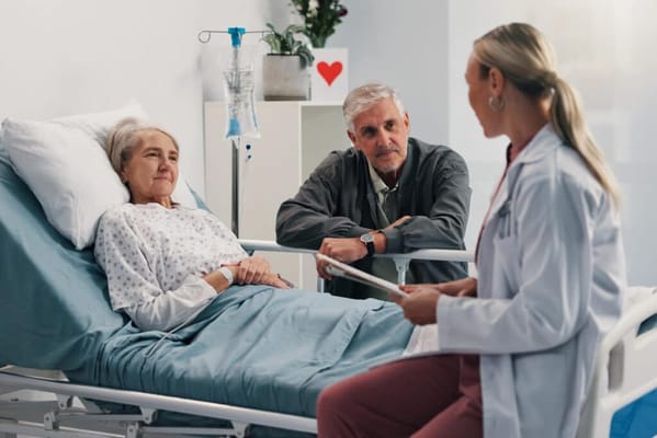A doctor discussing with a patient and a family member in a hospital room
