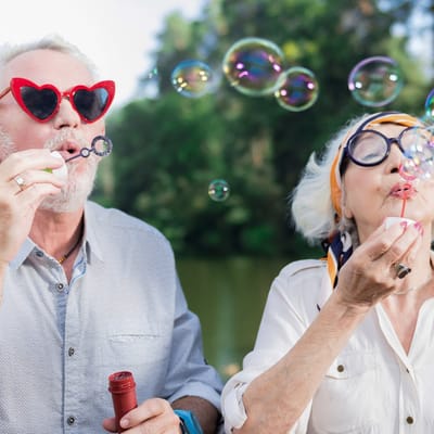 Seniors blowing bubbles outdoors in a garden