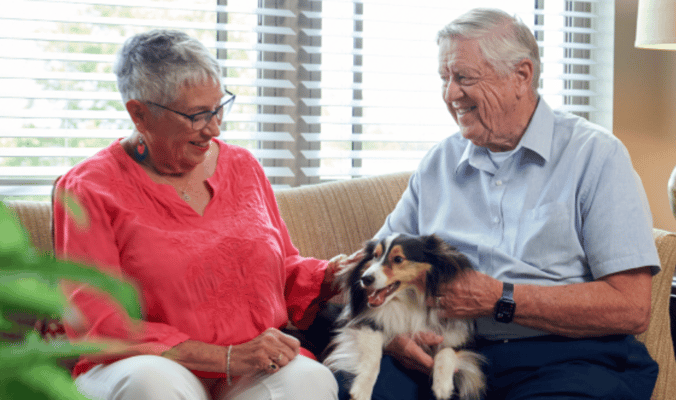 Residents enjoying time with a dog in a cozy living room