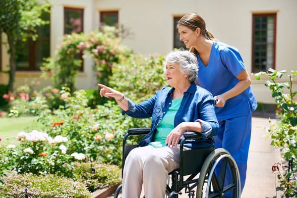 A caregiver assisting a resident in a garden