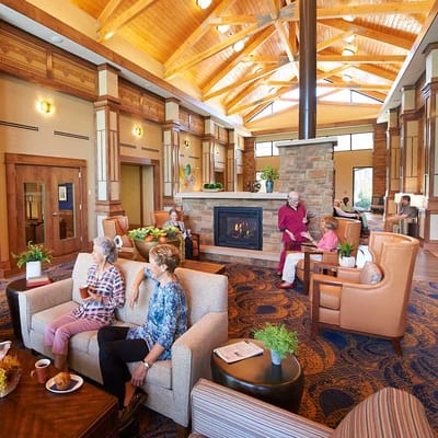 Residents enjoying a cozy common area with seating and a fireplace.