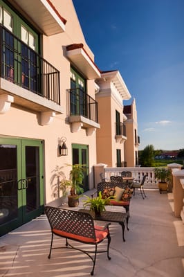 Outdoor seating area with plants and balcony view
