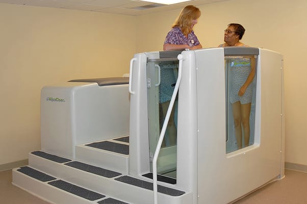 Staff assisting a resident in a therapy room