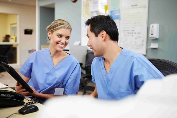 Two staff members smiling and interacting in a care facility