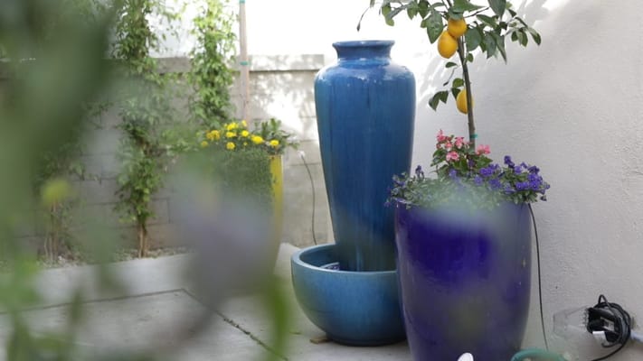 Outdoor fountain surrounded by colorful planters