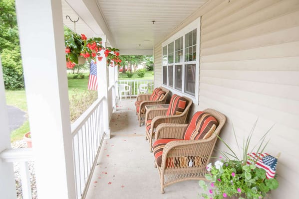 Porch area with chairs and hanging flowers