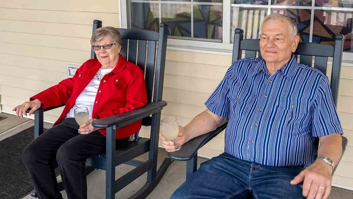 Two residents enjoying drinks on a porch
