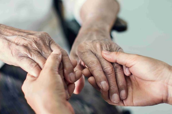 Close-up of hands joining together in care