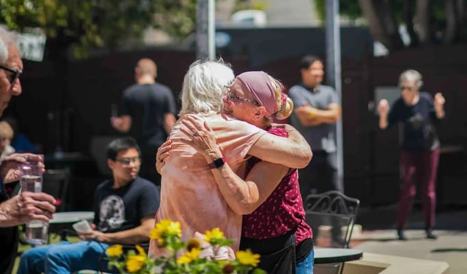 Residents hugging and enjoying time outdoors