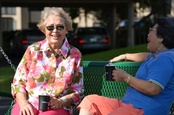 Two residents enjoying drinks outdoors in the garden